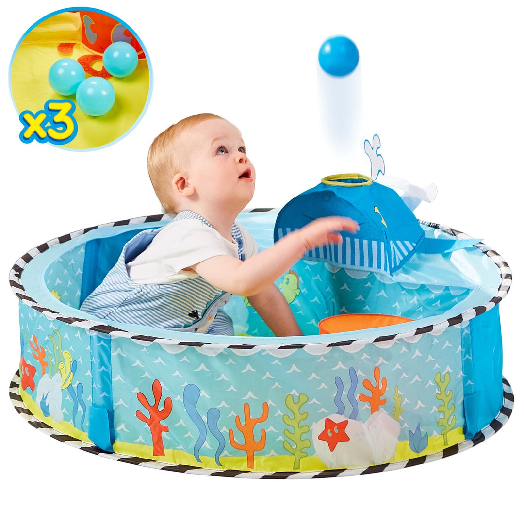 Baby playing in undersea-themed sensory ball pit with whale launcher, promoting hand-eye coordination and fun with play balls.